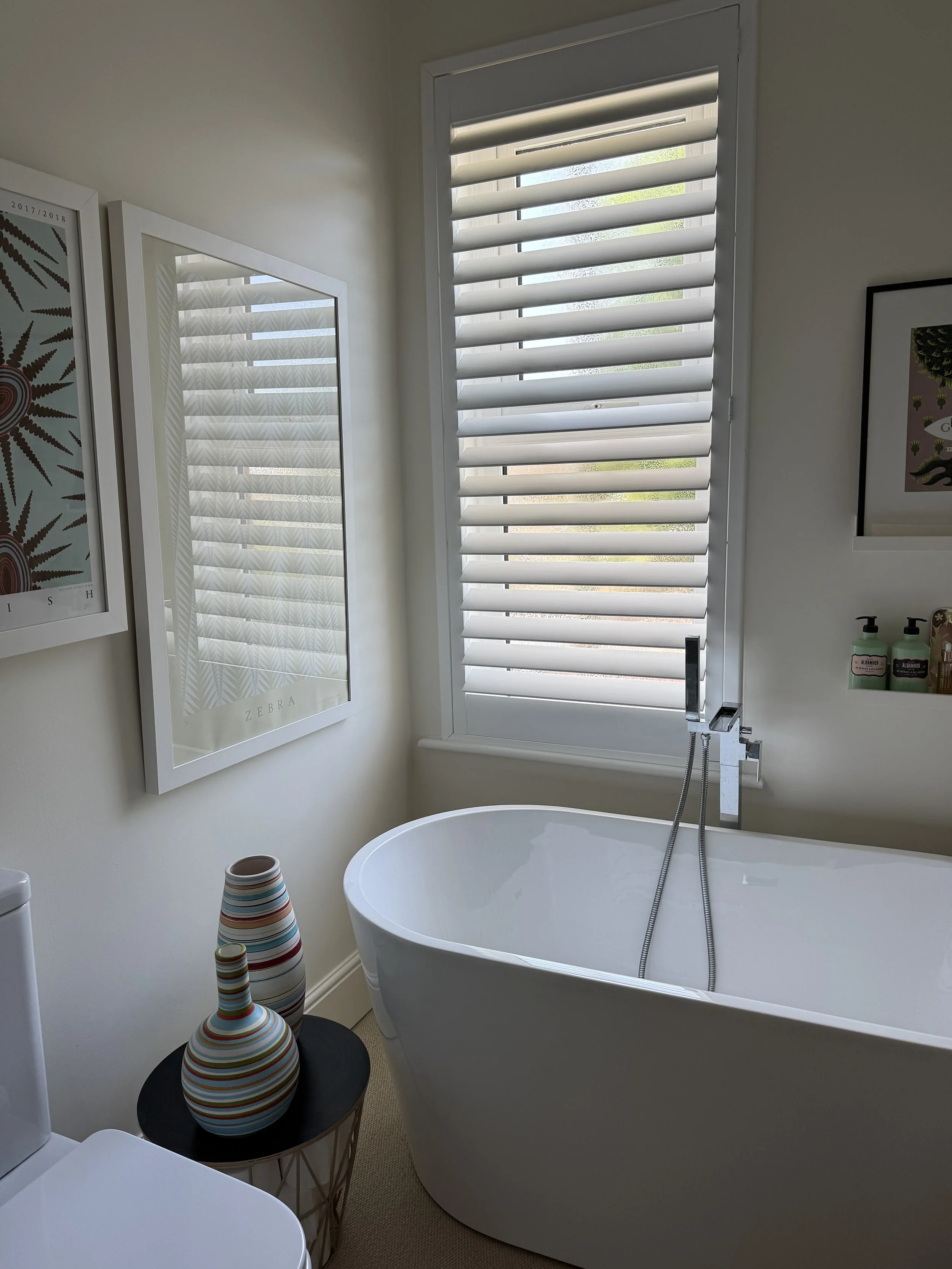 White plantation shutters provide privacy while maintaining a clean architectural look.