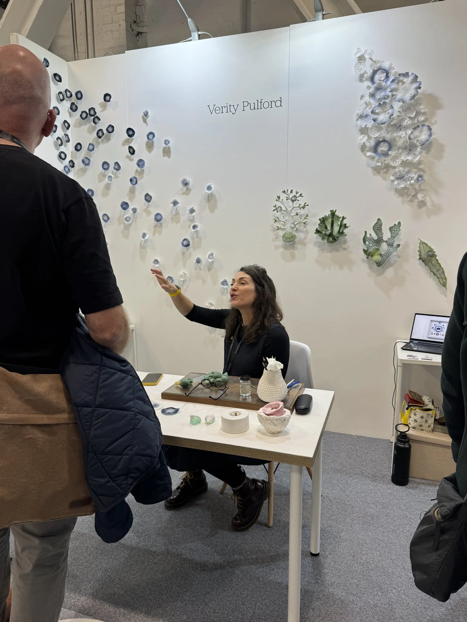 Clusters of white and blue glass forms arranged across a white wall, Verity Pulford in Making Spaces at Decorex 2026