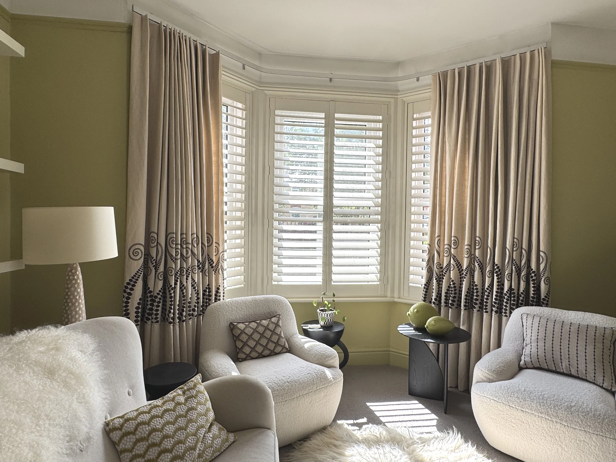 Bespoke linen curtains with decorative pattern placement and plantation shutters in an Edwardian bay window designed by Michelle Sucksmith Interior Designer.