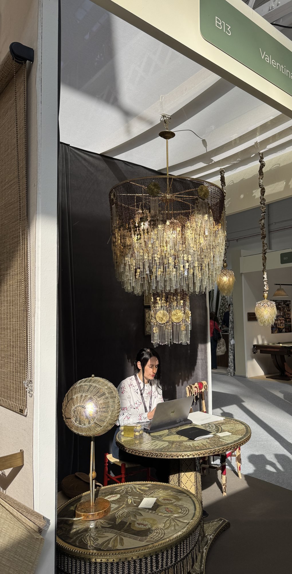 A large tiered chandelier hung with glass drops above a decorated table, Valentina Giovando at Decorex 2026