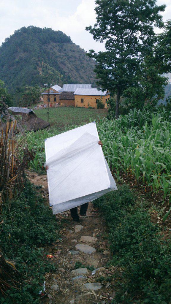 A CYF volunteer delivering whiteboards to the school. Man has been able to continue teaching classes using school supplies and temporary classrooms funded by CYF donors.