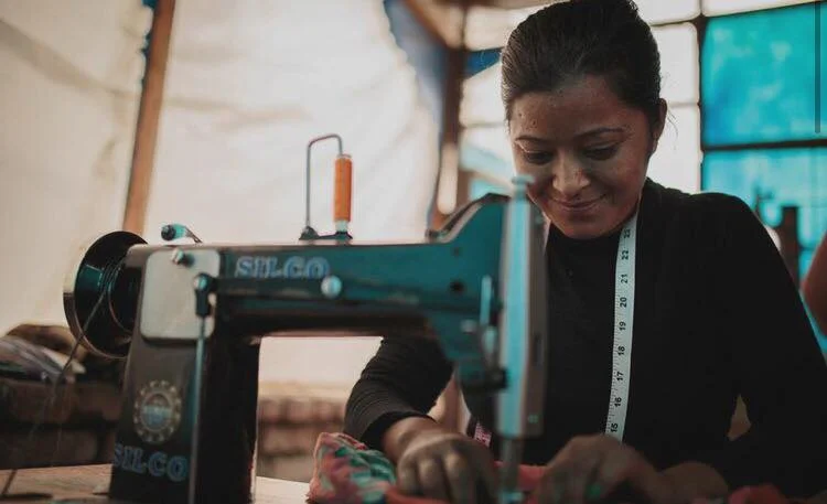 Head stitcher Kamala Tamang sewing a Riya Tote in the Haushala Creatives workspace.