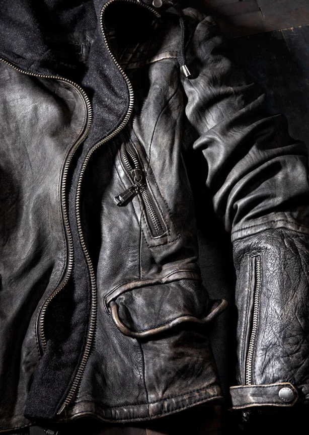  Still life featuring fashion soft-goods product, a dark leather jacket.&nbsp; Image is cropped tight to show off the texture of the leather and details on the hardware.&nbsp; Photographed in studio in New York. Styled by Jill Edwards. 