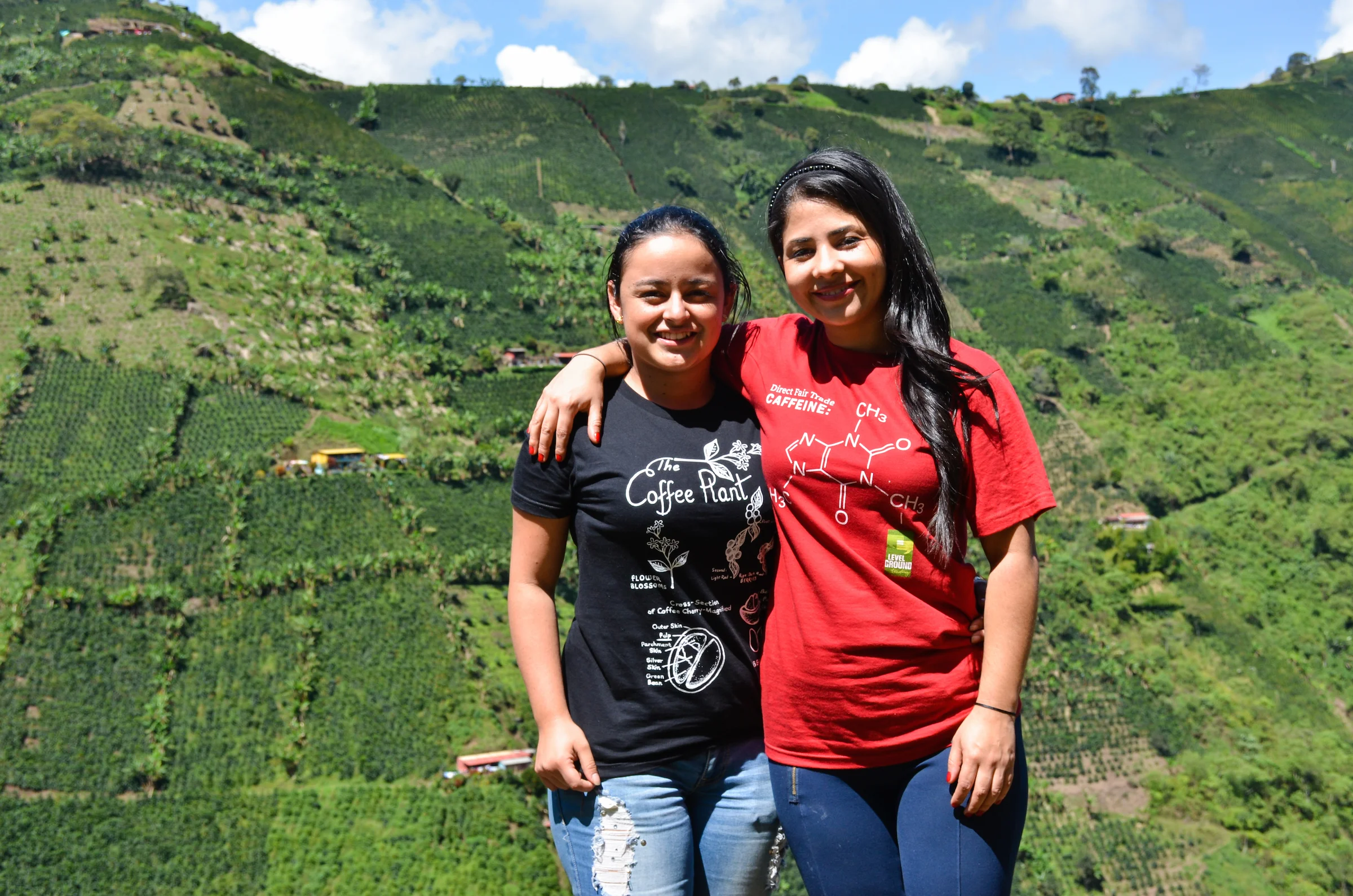 Elizabeth and Bibiana stand against the incredible steep slopes of coffee.