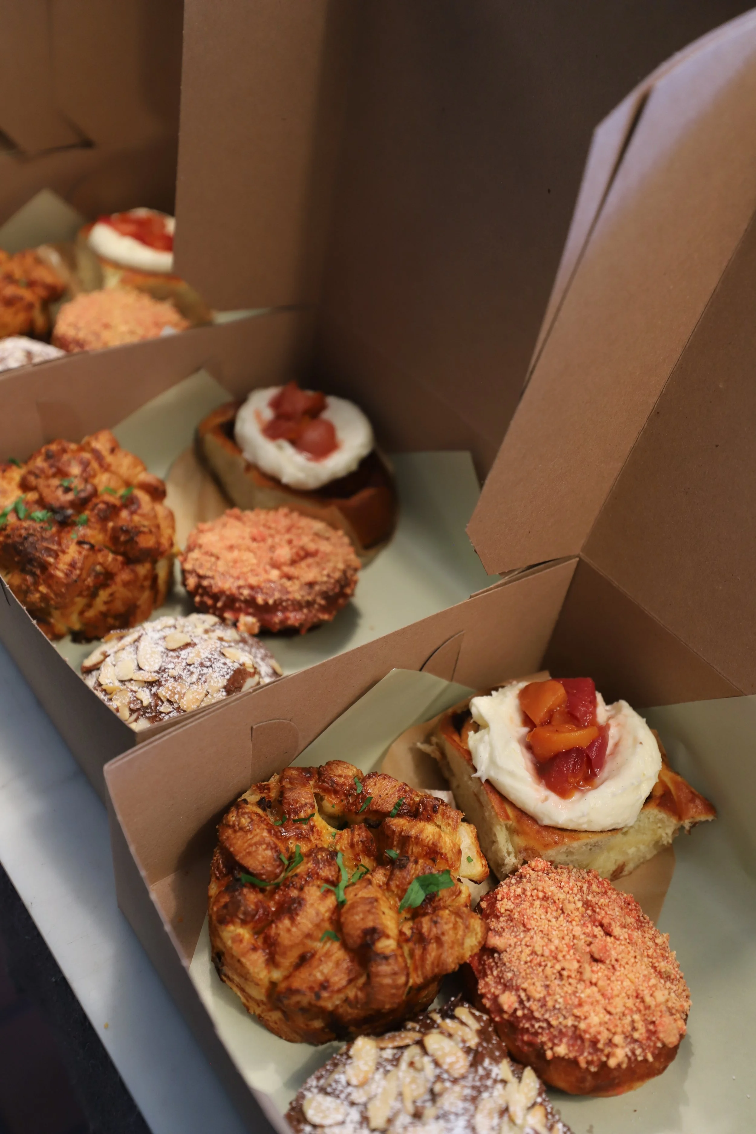 Lined up boxes with assorted pastries.