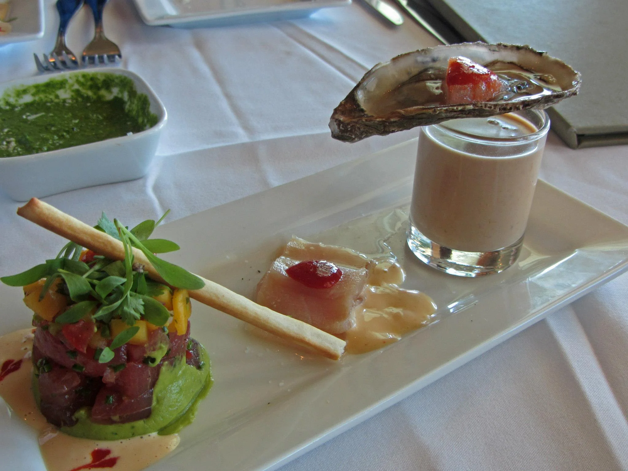 Ahi with mango salsa, avocado, wasabi aioli; hamachi sashimi with jalapeno pepper jam and limoncello vinegar; Lobster bisque with porcini infusion topped with a Malpeque oyster and sriracha granita;