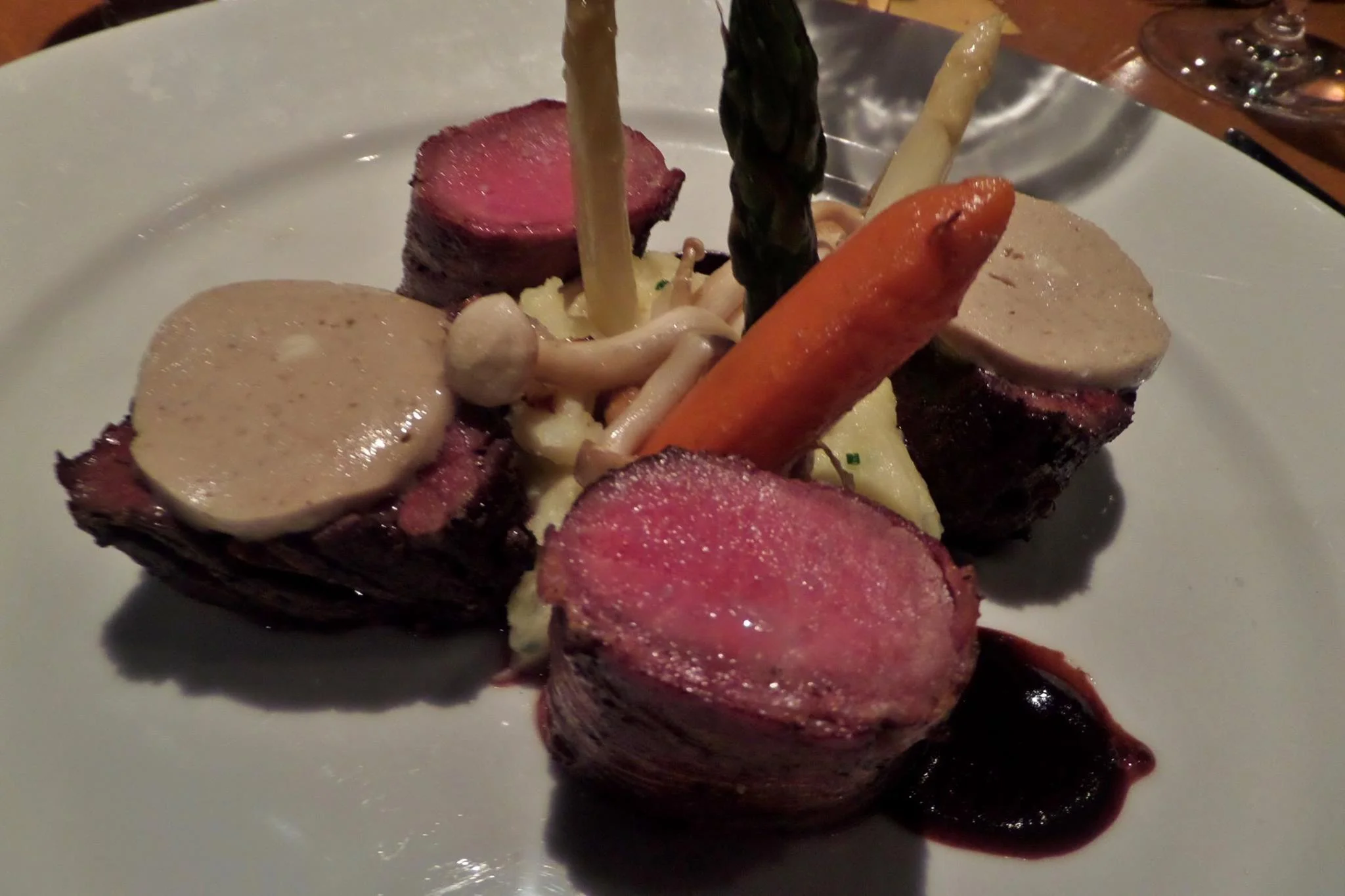 Hanger steak with foie gras butter + pancetta-wrapped lamb loin, with potato puree, white asparagus, enoki mushrooms, red wine reduction sauce.