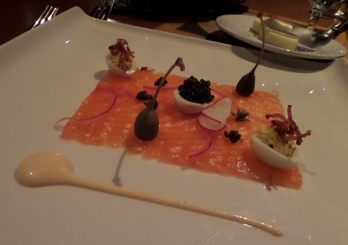 Citrus vodka-sake cured salmon with caper berries, radish, and deviled eggs with bacon and Osetra caviar.