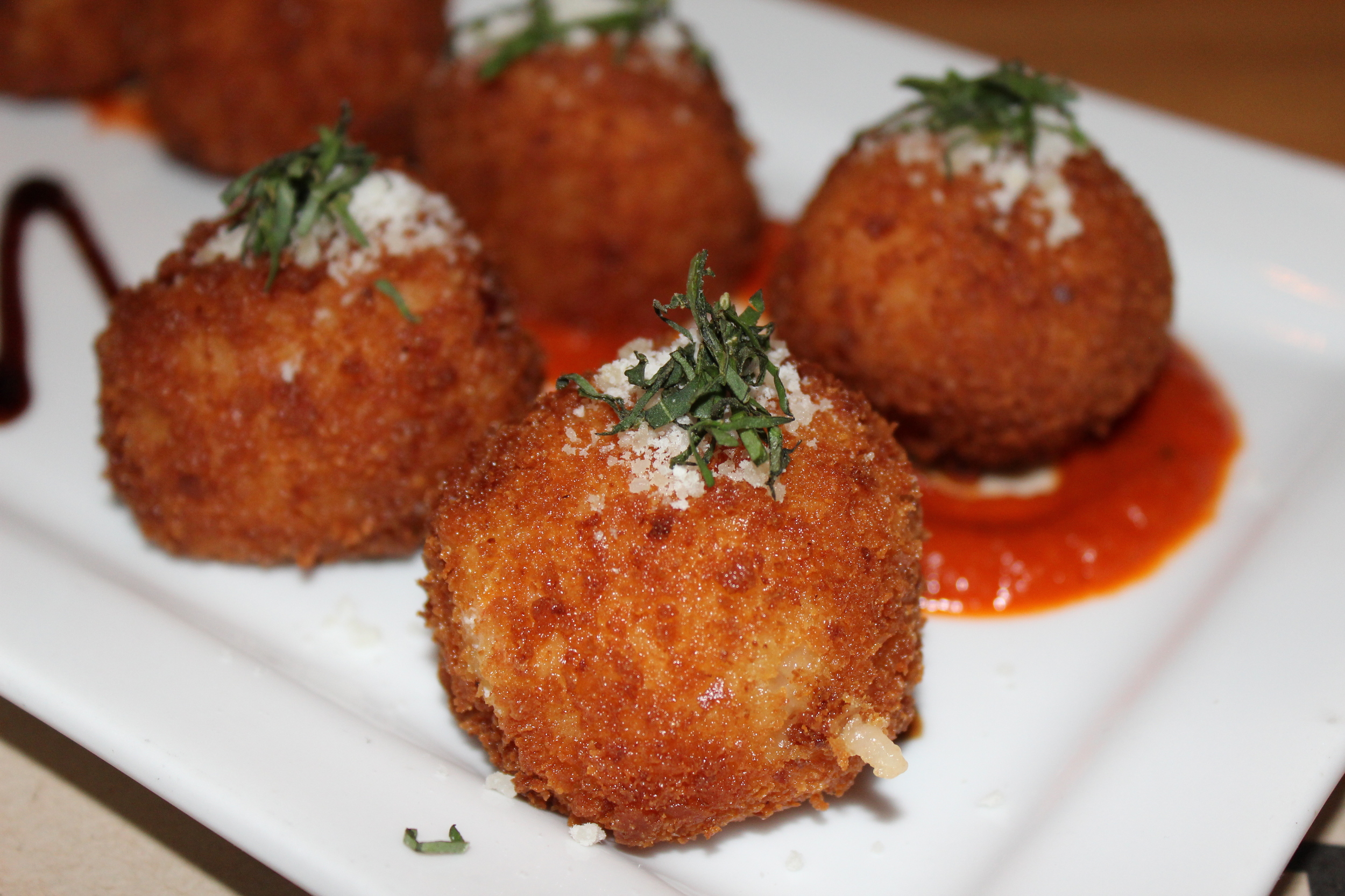 Arancini filled with house-pulled mozzarella with pomodoro and balsamic reduction