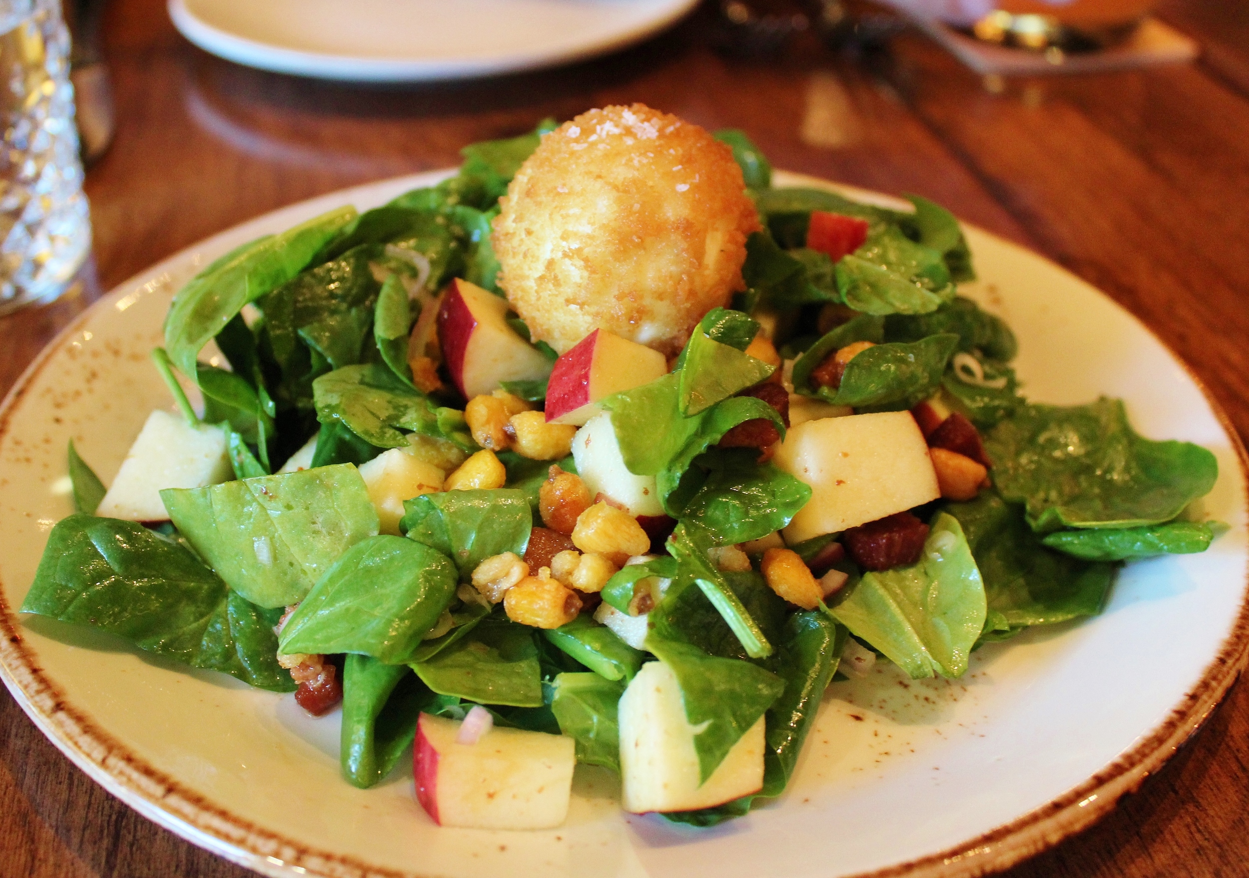 Spinach salad with crispy soft-boiled egg, apple, shallots, corn nuts, bacon vinaigrette