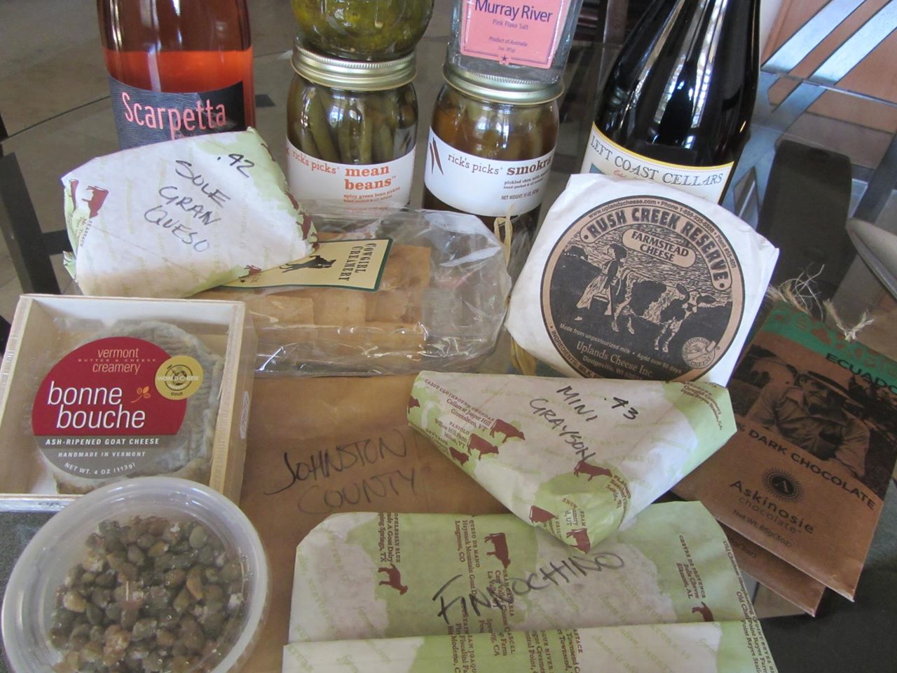 Scarpetta Wine Spumante Brut Rosé, Belinda's pickles, Rick's Picks Smokra & Mean Beans, Murray River salt, Left Coast Cellars Pinot Noir, Roth Kase Sole Gran Queso, Cowgirl Creamery crackers, Uplands Rush Creek Reserve, Askinosie Ecuador chocolate, Vermont Creamery Bonne Bouche, Meadow Creek Mini Grayson, Caravaglio Capers in sea salt, Johnston County Mangalitsa ham, and Finocchiona. 