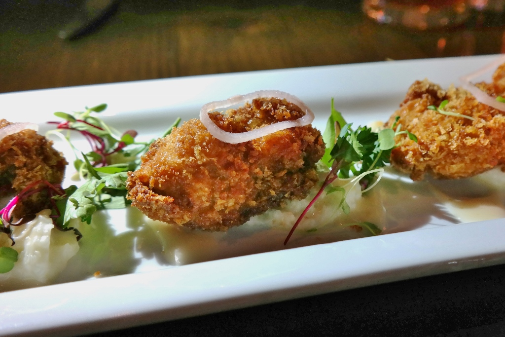 Fried oysters with creamy grits, Meyer lemon vinaigrette and microgreens