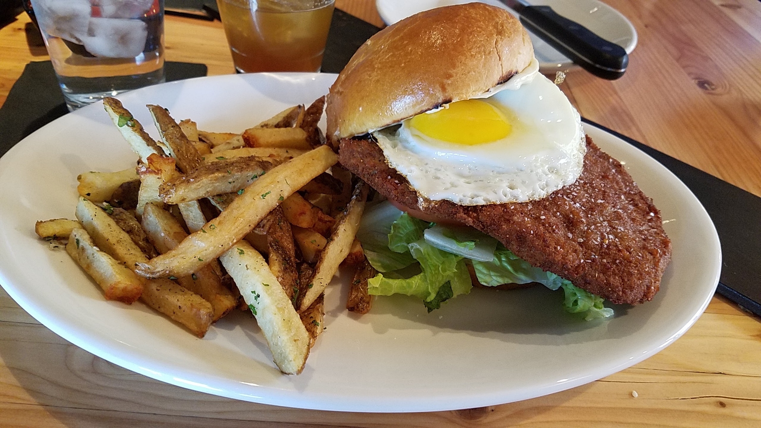 Beef milanesa sandwich topped with a fried egg