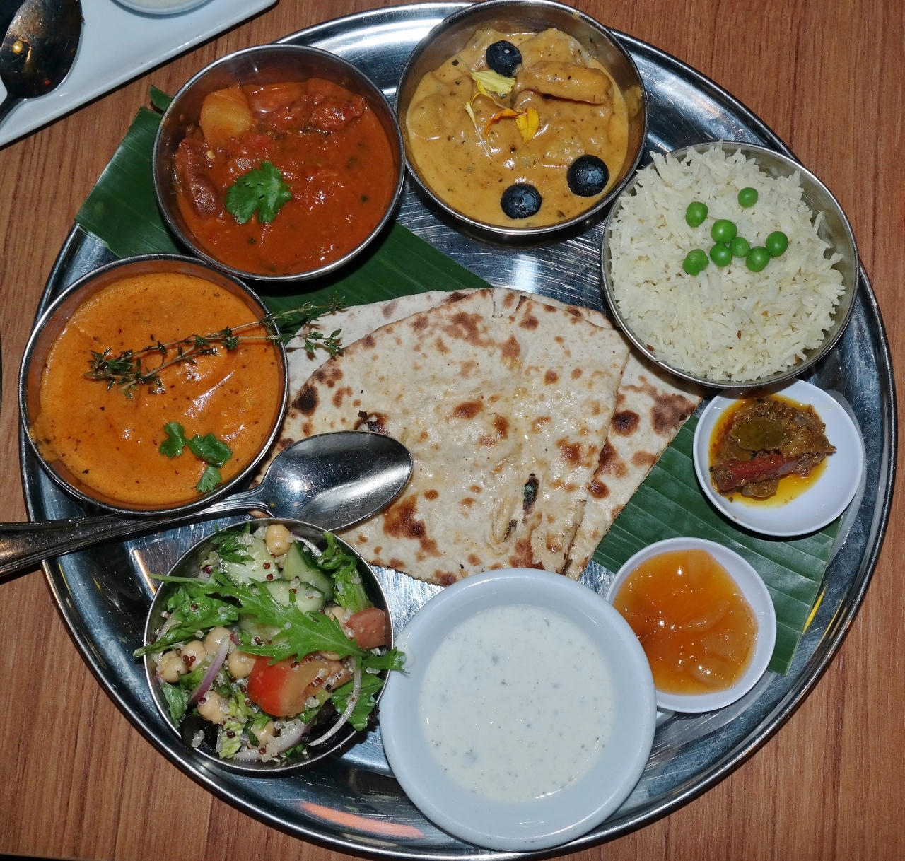 Tikka masala (chicken, tomato sauce, cream, cashew paste, fenugreek), Goan vindaloo (lamb, wine, red chili, curry leaves, mustard seeds), Kashmir korma (shrimp, cashew cream, fruit, ground spices) and quinoa salad with chickpeas and tomatoes. 