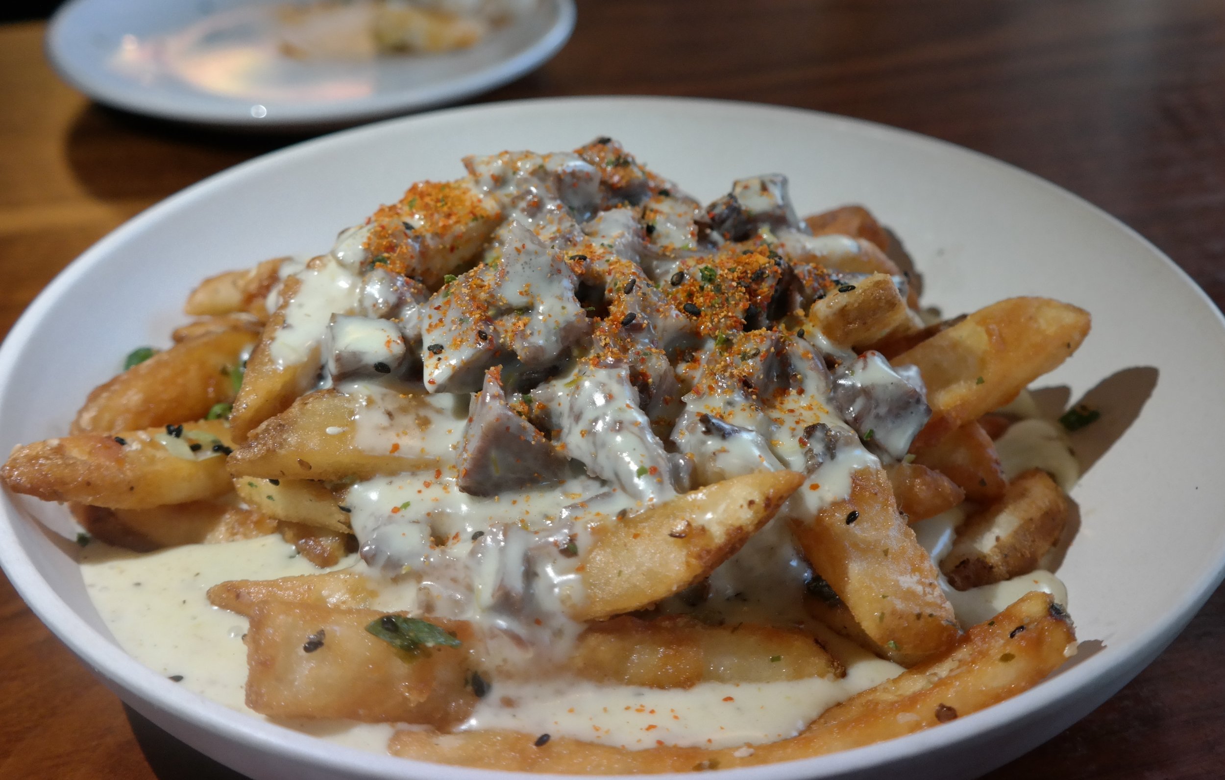 Umami Fries with barbacoa, cheese sauce, and shichimi