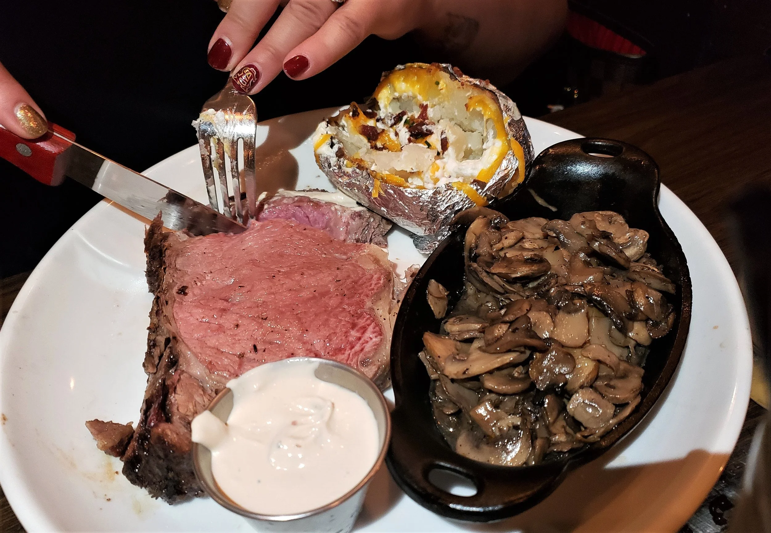Prime rib with sides of loaded baked potato and mushrooms ( Christina Barrueta)