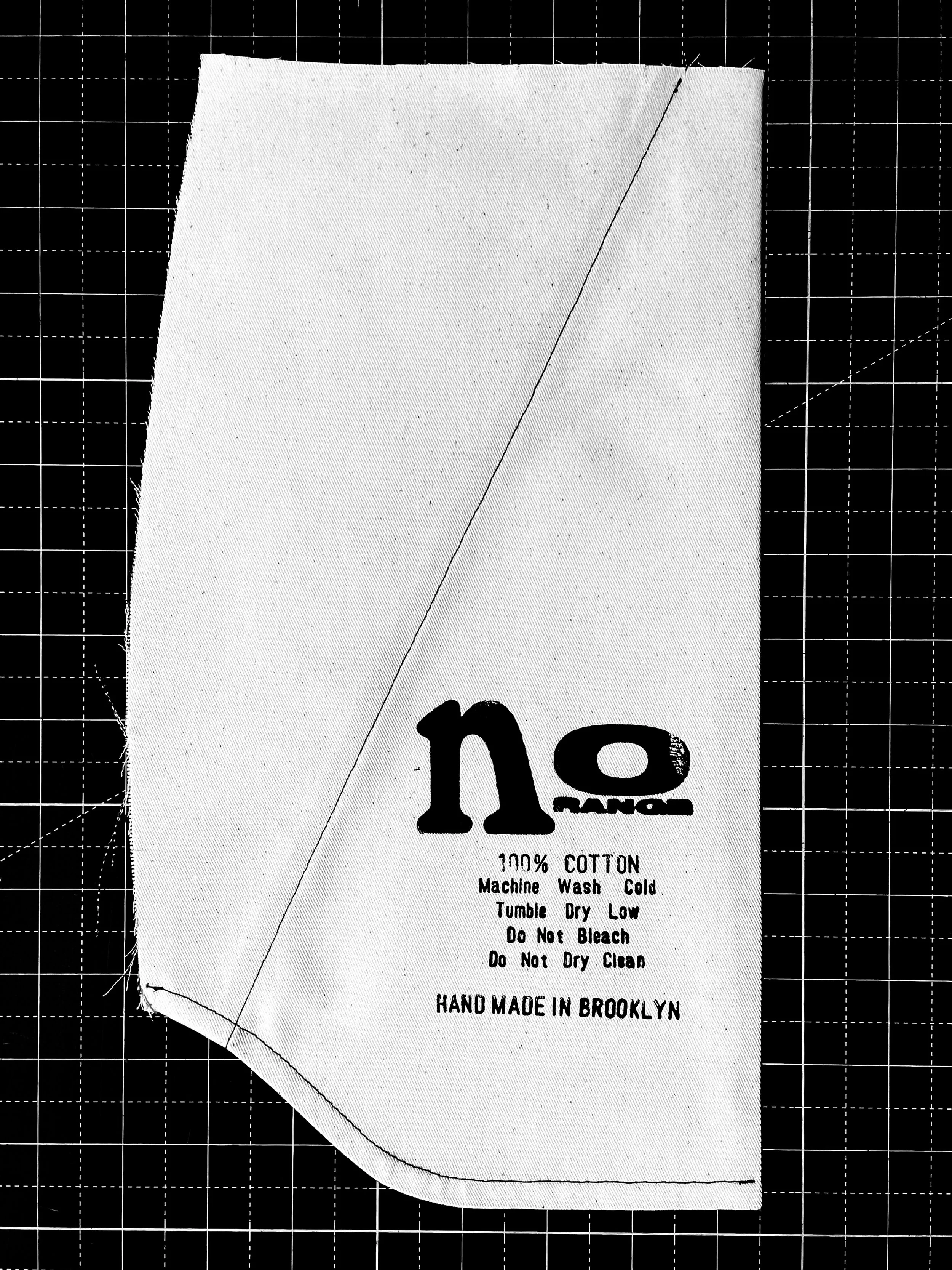 Cloth piece with "no" print, washing instructions, and "HAND MADE IN BROOKLYN."