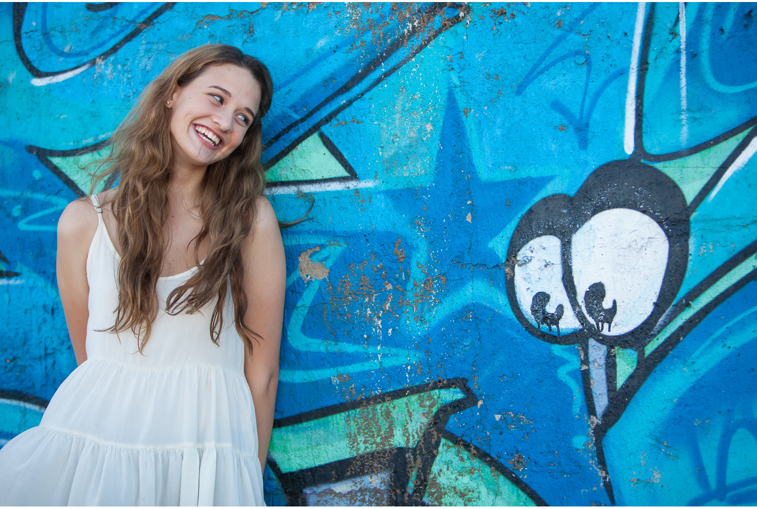 Denver high school senior pictures, gorgeous Maddie smiling at graffiti eyes | photographer Jennifer Koskinen | Merritt Portrait Studio