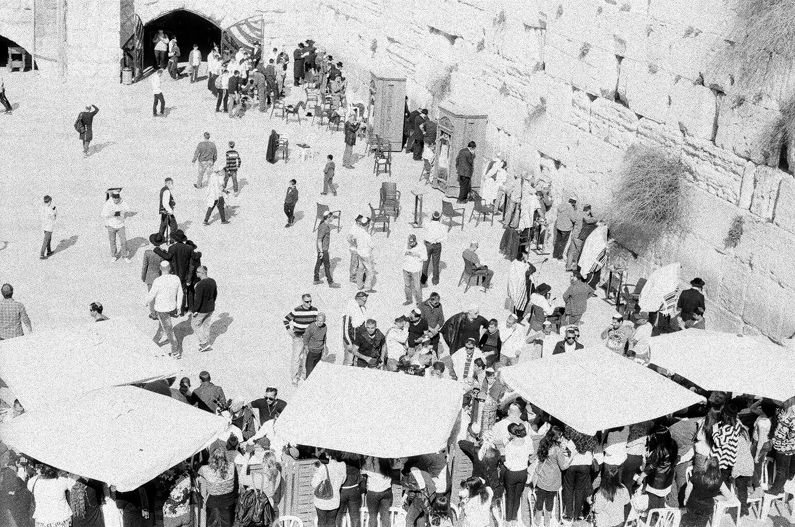 A Bar Mitzvah for a boy at the Western Wall: See the women standing on chairs to peer over the division to watch the ceremony