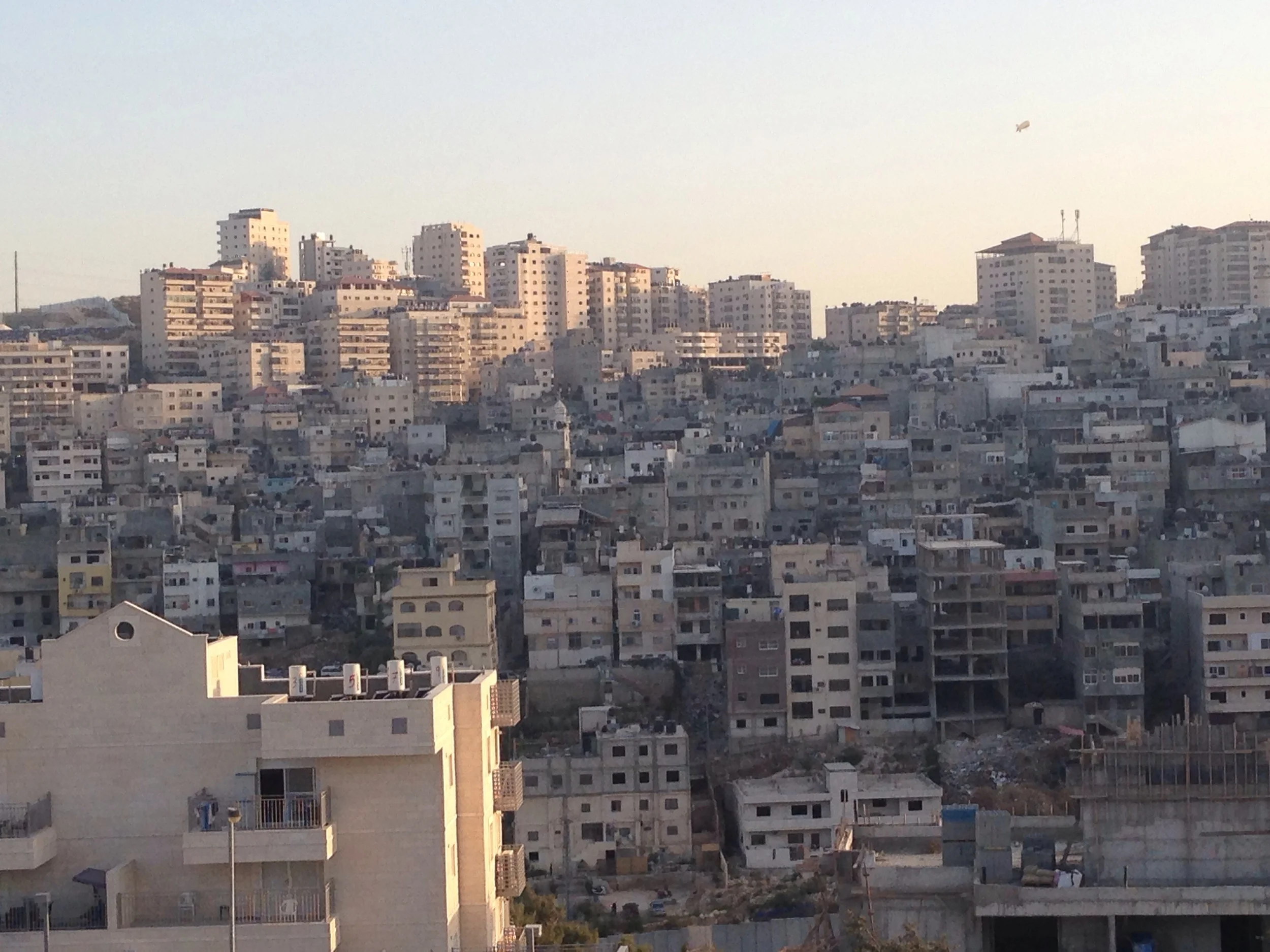 Shu'afat Refugee Camp in the distance to the right (in the shadow of the hill), new apartment in Pisgat Ze'ev in the foreground.