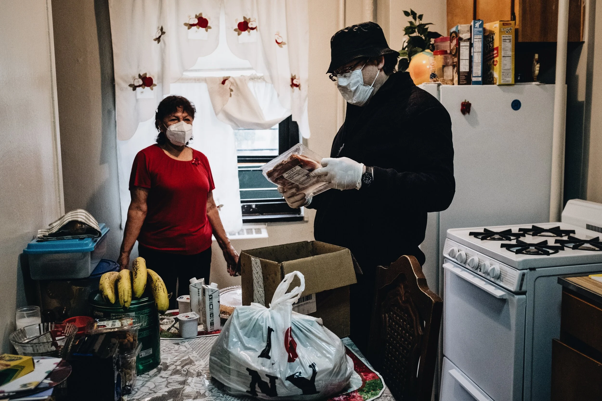Father Pedro Gonzalez makes a food delivery to Gloria, a 75 year old churchgoer originally from Salvador.