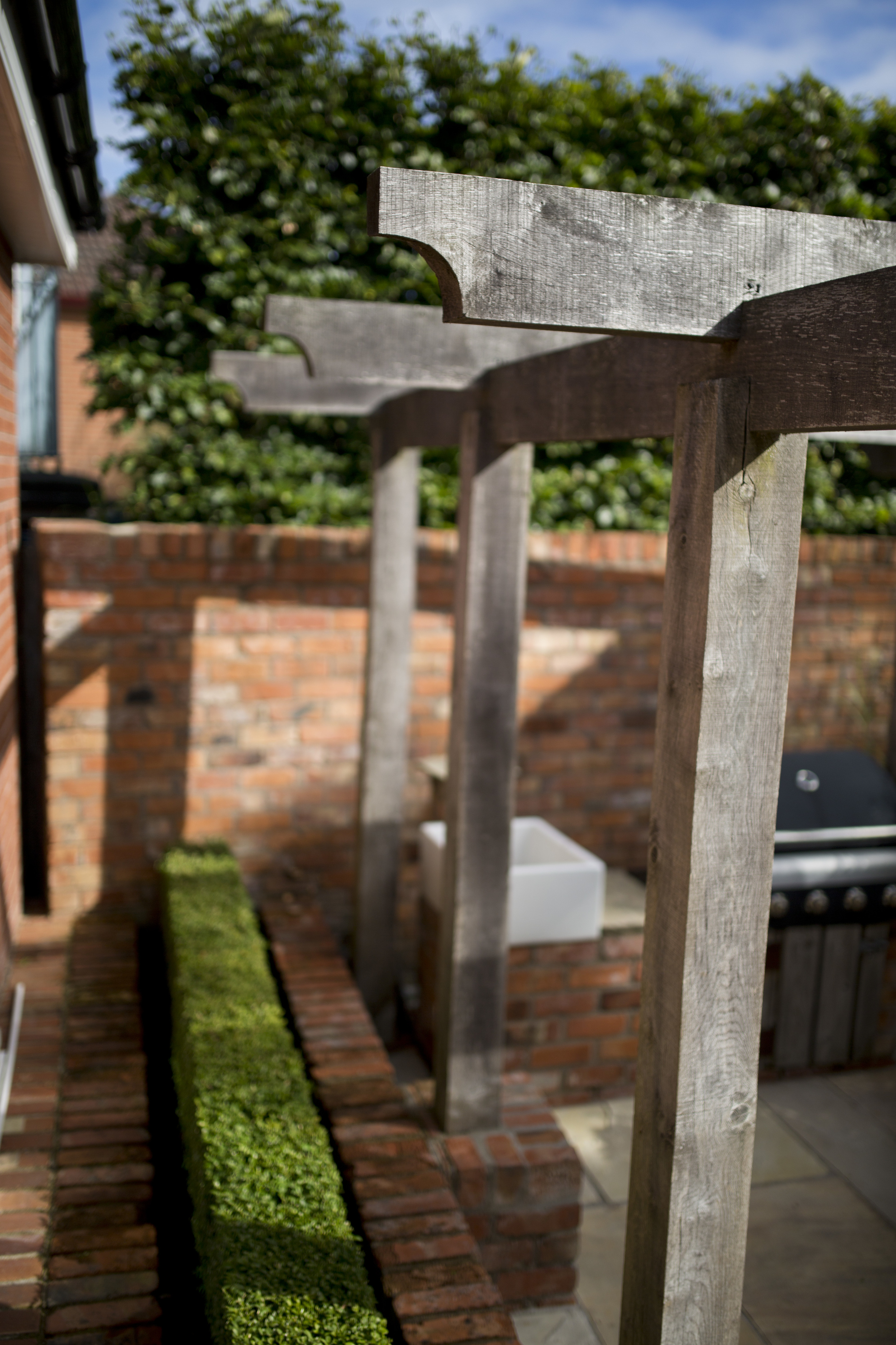 courtyard garden with oak pergola and belfast sink at bbq area