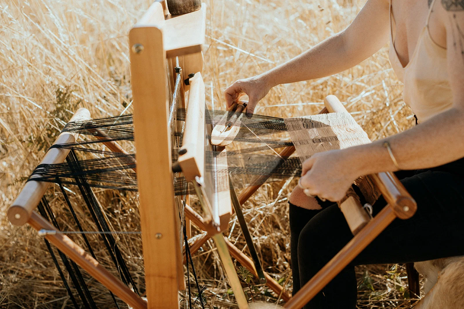 Up close portrait of bohemian woman weaving in tall grass