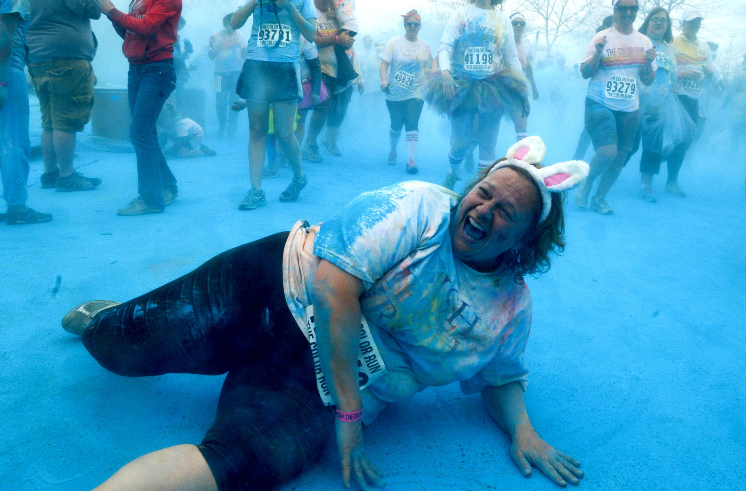  Jen Claiborne rolls on the powder covered ground, to get more color on her clothing, during the May, 2013 Color Run, held in Nashville Tennessee. 