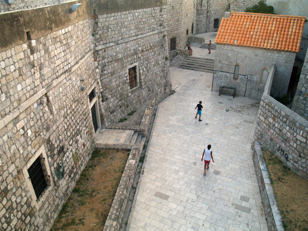Boys play behind Dubrovnik’s old city wall.