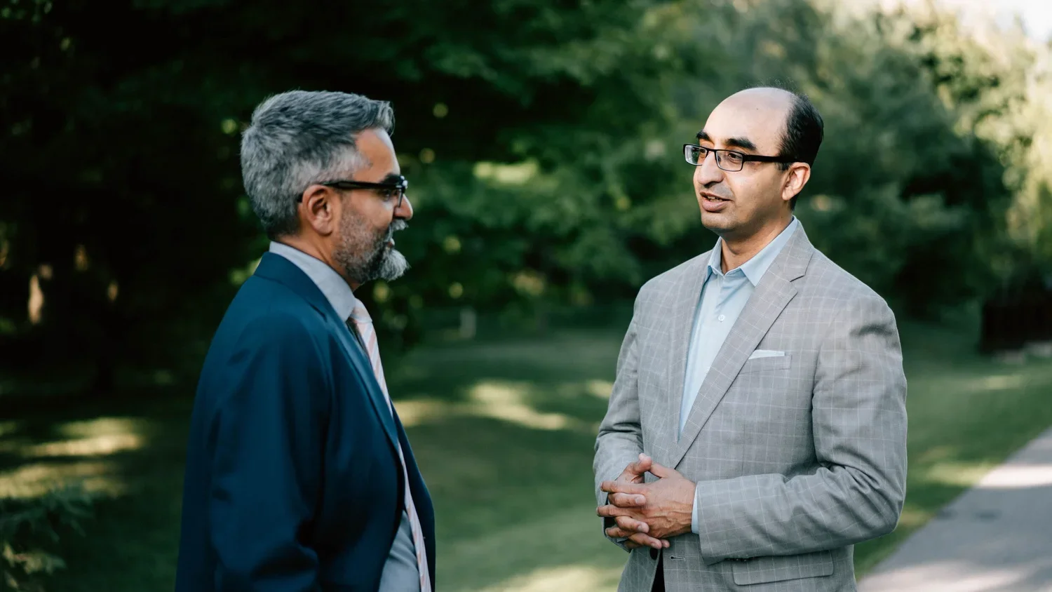 Authors Ahsan Khan and Shazad Ahmad talking outdoors
