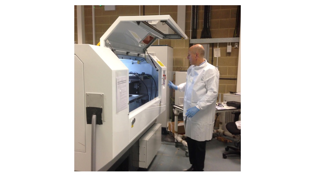 Tom Mood, a member of the Airing development team, adjusts the settings on a laser micromachining system in the manufacturer's facility.