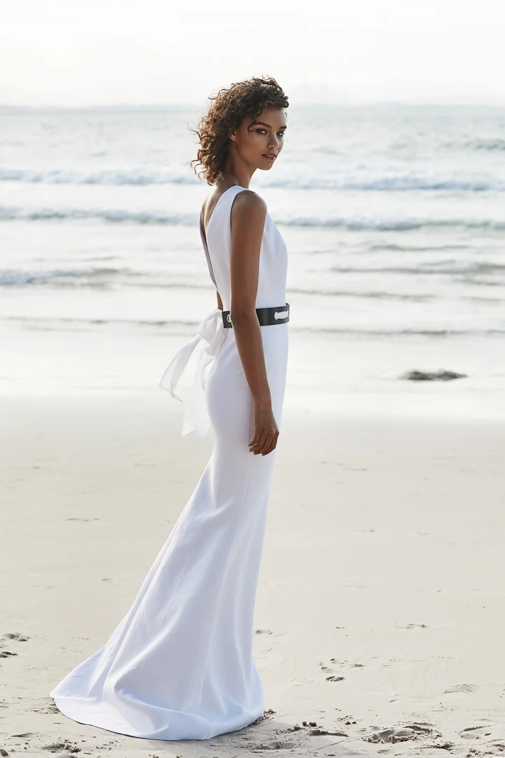 The Cape gown is a classic style with high front neckline and plunging back. Featureing a slim A-line skirt and petite train.