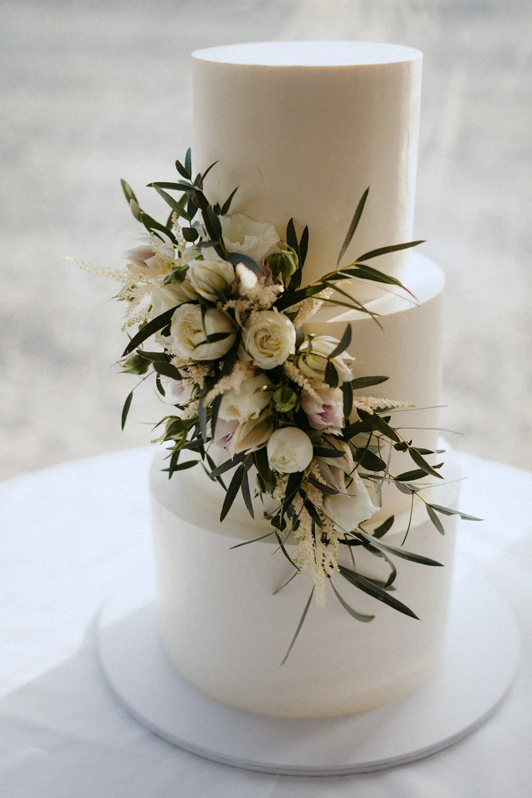 The chocolate mud cake had 3-tiers and a simple design. White buttercream icing was adorned with florals.