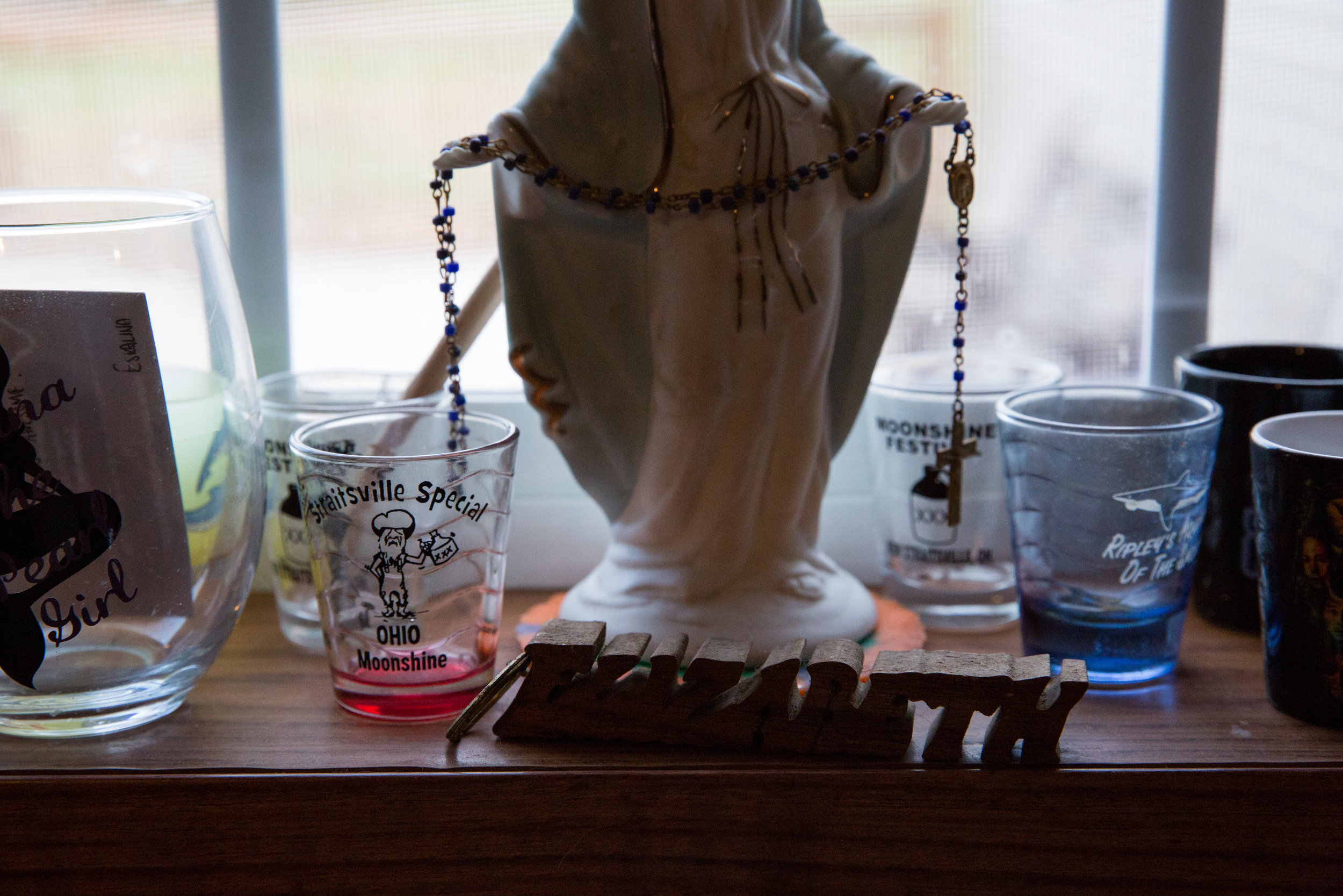  Missy's windowsill is full of shot glasses from New Straitsville, where she grew up, as well as a statue of Mary and keychains with the names of all three of her children. 