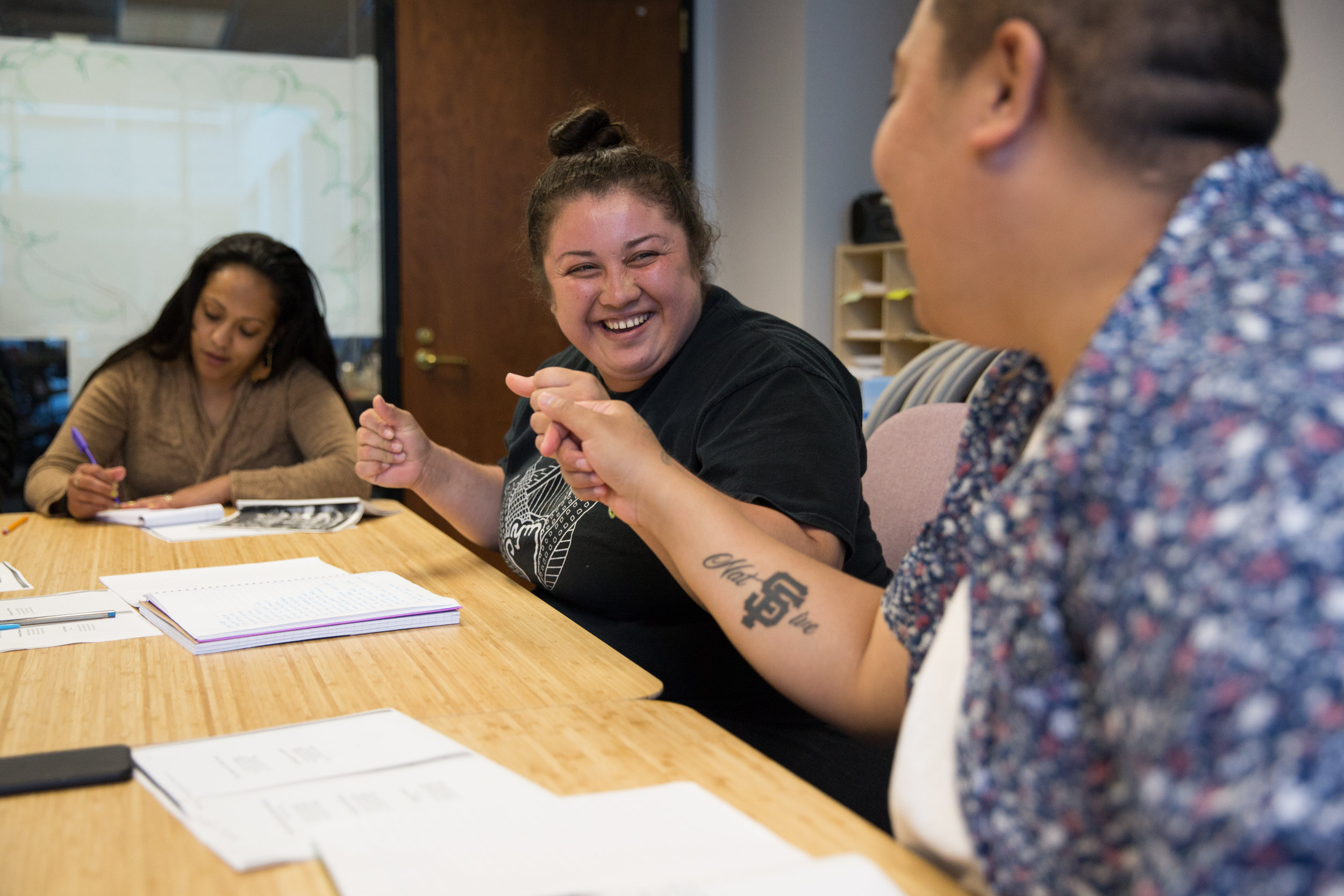  Lucero Herrera, left, and K.I. Ifopo fist bump after Lucero read her poem out loud during a Writing to Power workshop. Many of the staff members knew each other before coming to the center, like Lucero and K.I. who were incarcerated together, and ha