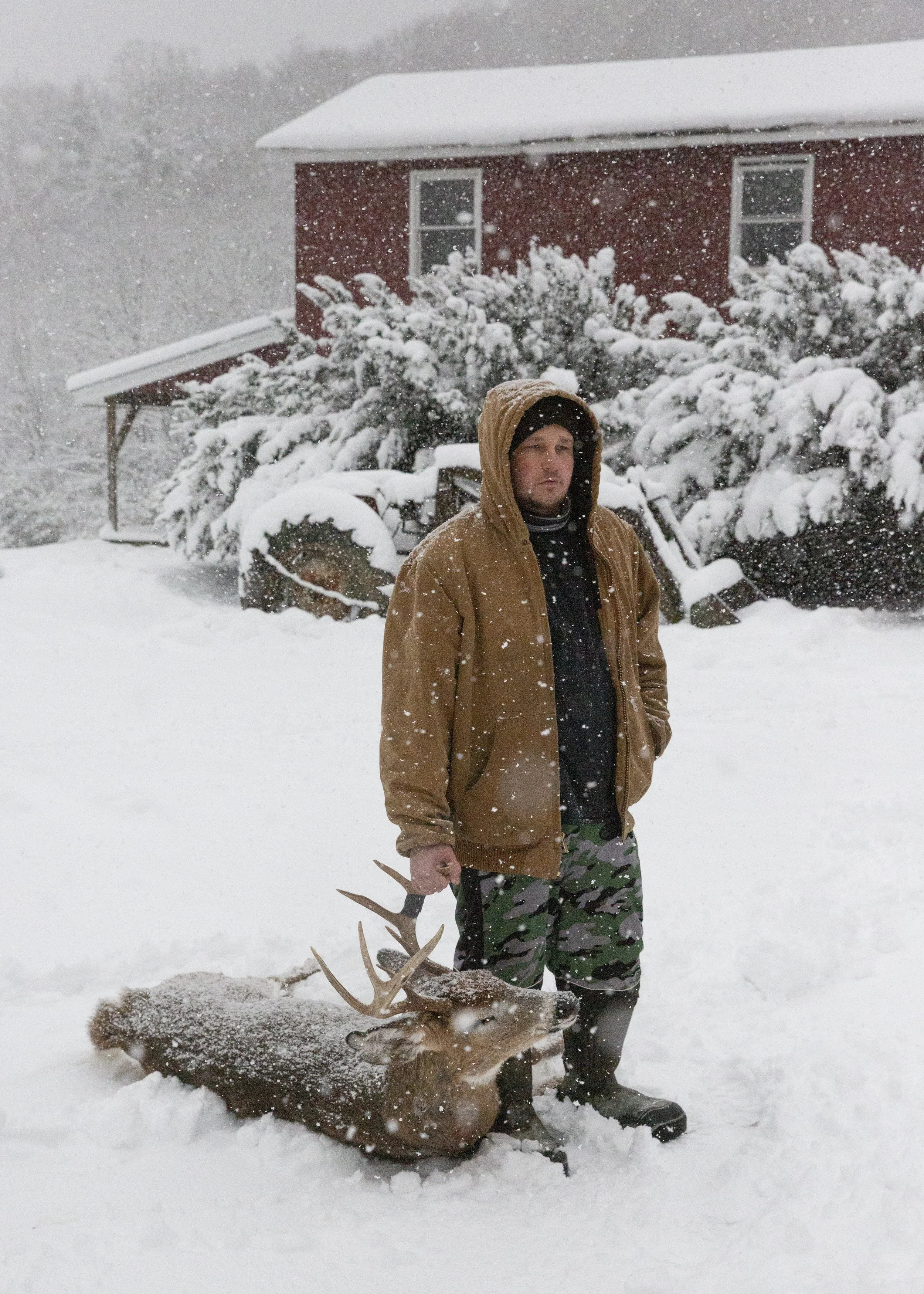  Trevor Tabor drags in a buck from a storage shed outside. Tabor often works seven days a week at the slaughterhouse he manages in Sharon, Vt., and processes wild game on the side. 