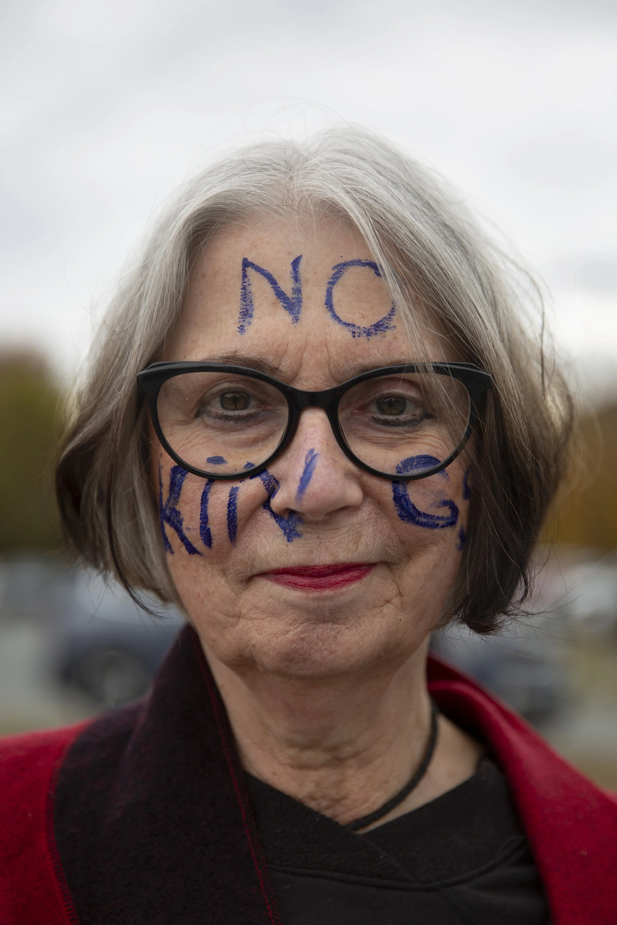  Joan Mikasha-Alexander, of White River Junction, Vt., sports a No Kings slogan written across her face during a No Kings protest in White River Junction, Vt., on Saturday, Oct. 18, 2025. 
