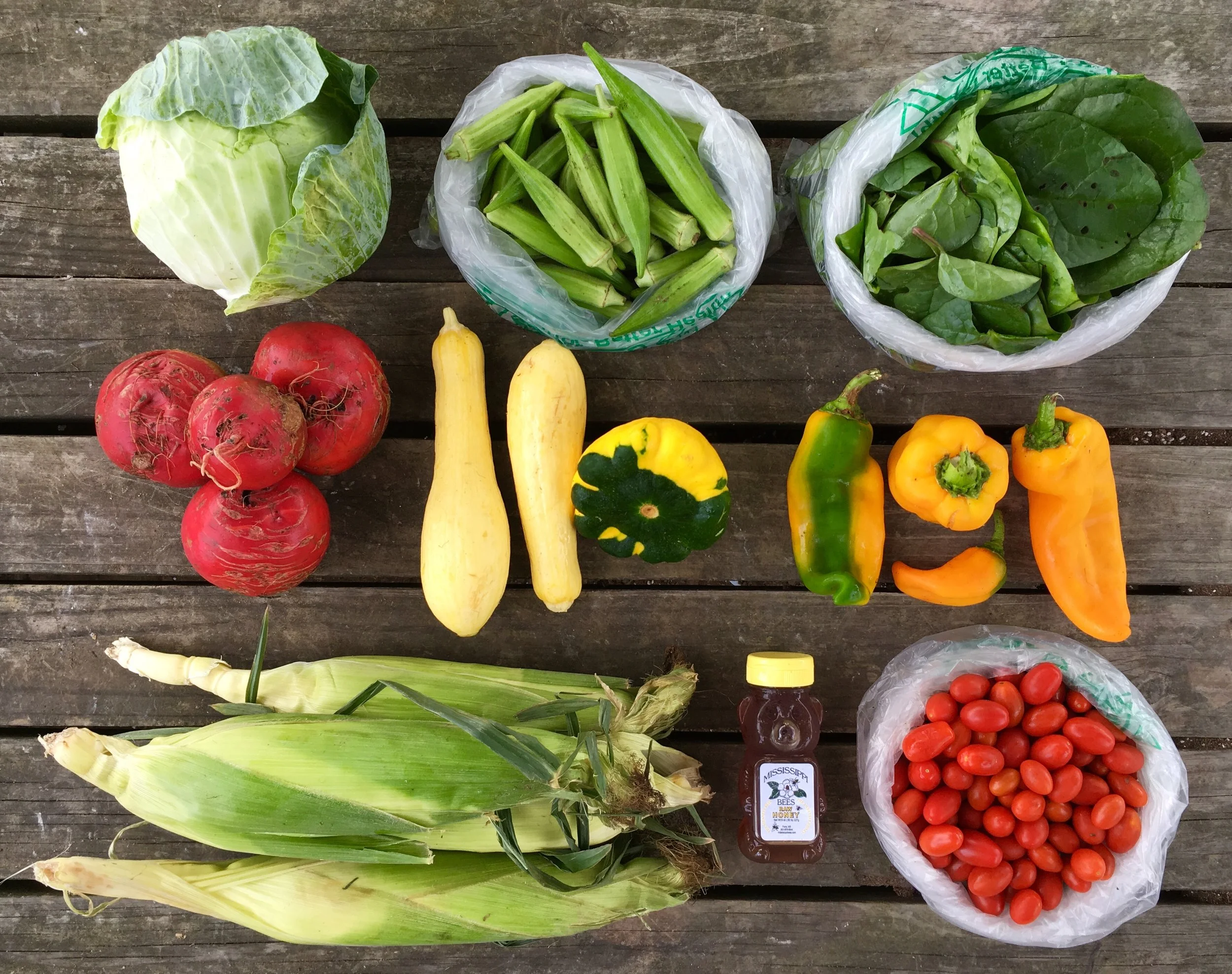 Top Row: Cabbage, Okra, and Spinach Middle Row: Chioggia Beets, Squash, and Sweet Peppers Bottom Row: Corn, MS Bees Honey, and Cherry Tomatoes