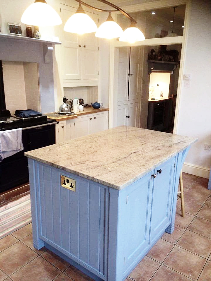 Bespoke island, finished in Little Greene "James" with granite top, integrated power points, German soft close hardware, and an all real oak interior.