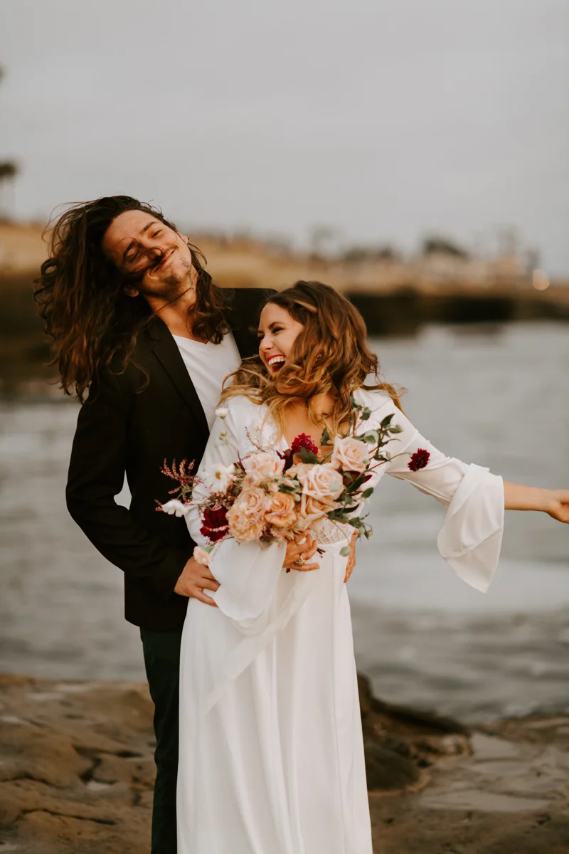 Dana Lagomarsino of Just Lago smiling with her partner during a wedding portrait.