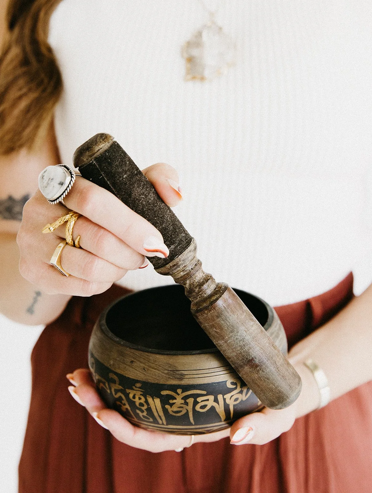 Hands playing a singing bowl during a corporate wellness sound meditation session.