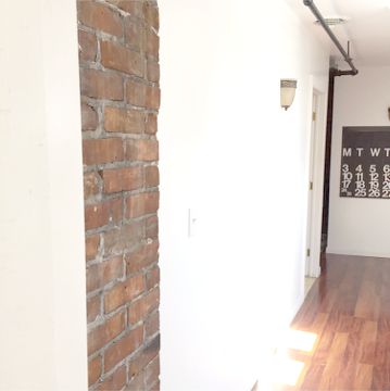 Our back hallway is long and narrow but has some of the best light and breeze in the entire house! We've left it pretty bare which allows the Stendig Calendar and exposed brick to do the talking!