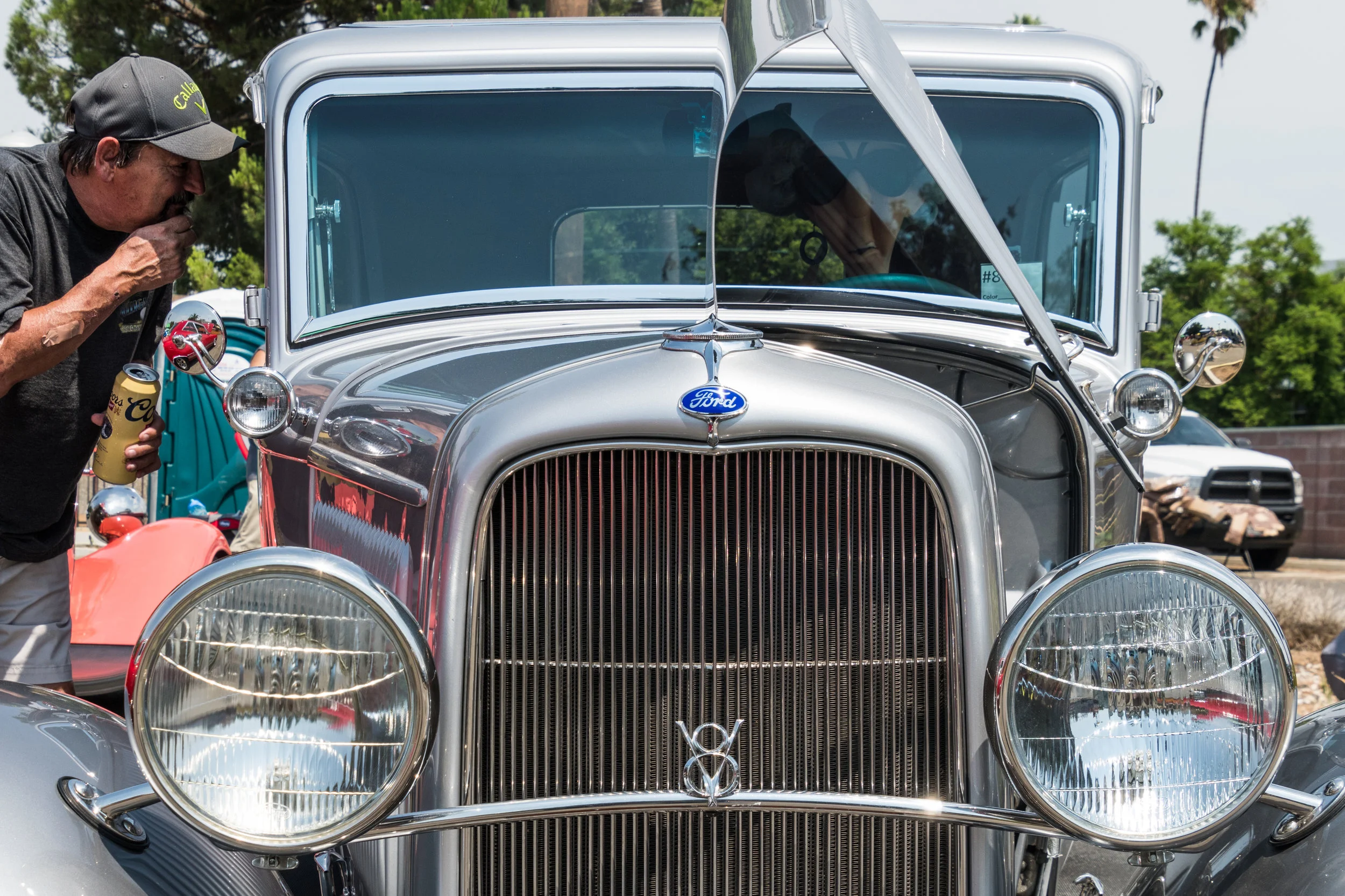 Curiosity strikes a man as he peers through the window of a classic Ford V8 during the Labor Day Car & Bike show hosted by Riverside Elks Lodge #643.