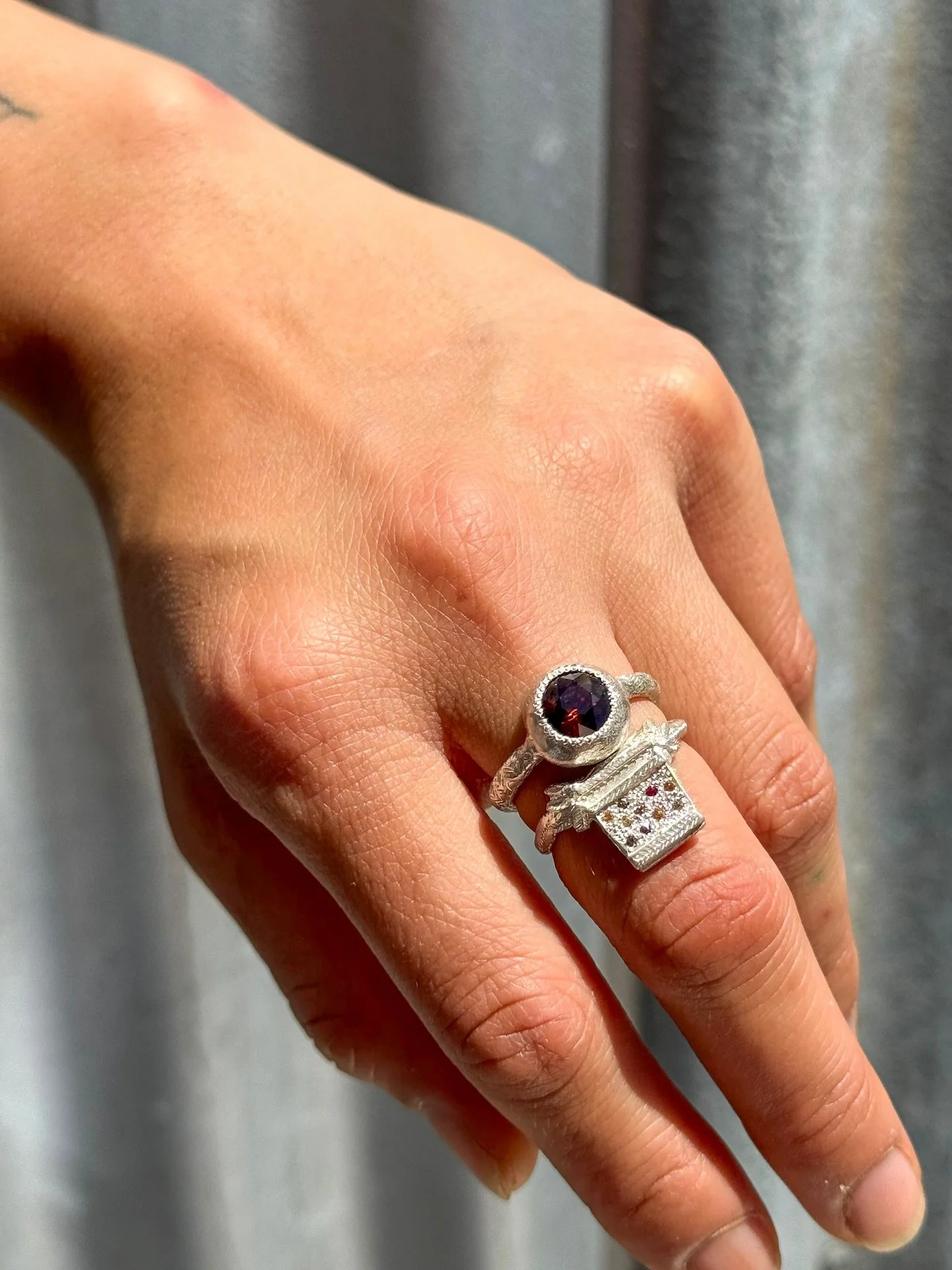 Dream ring stack.
Handmade sterling silver #118 ring set with deep orange Australian zircon. Worn with #115, handmade in sterling silver with a beautiful combination of champagne diamonds, yellow sapphires and rubies.

There is only one of each of th
