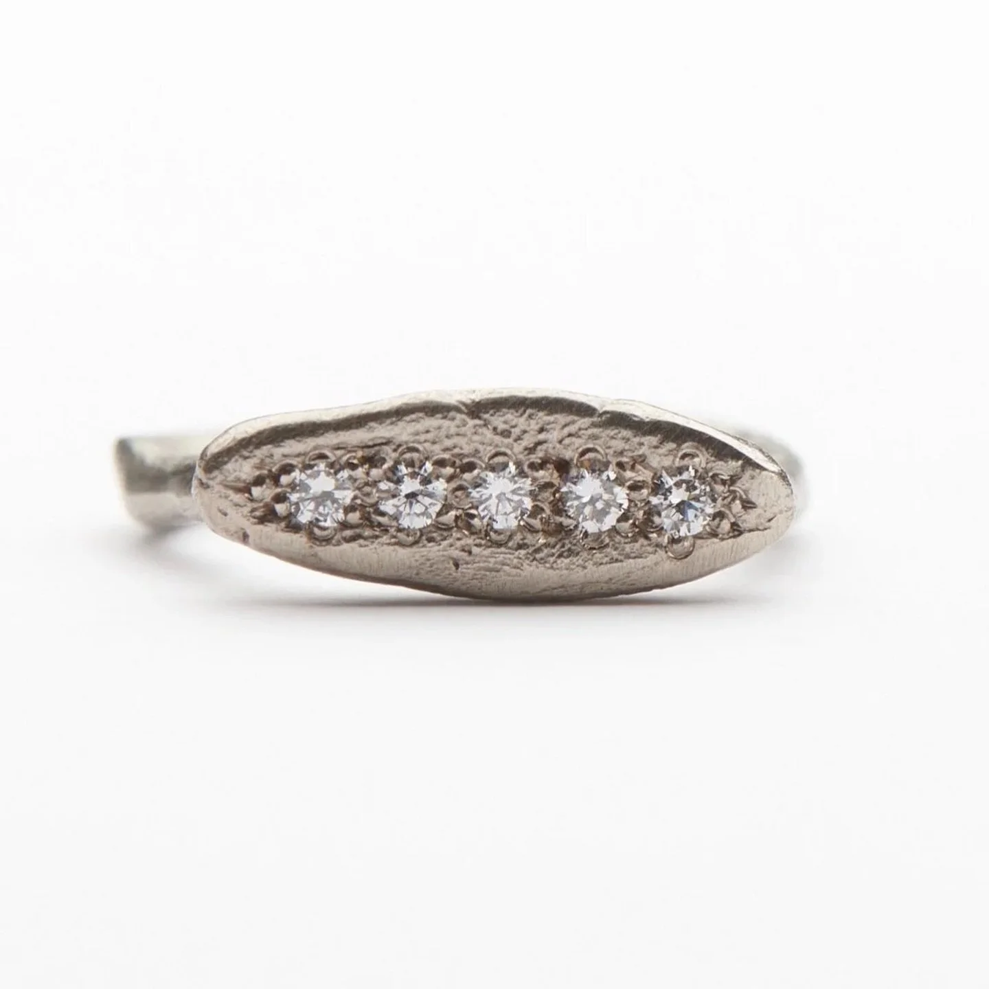 I first made this ring many years ago. I wanted it to feel worn, a ring that looked as though it had lived a long life, a history. Though it has been through much, it holds a line of gemstones with quiet confidence, their perfection resting within it