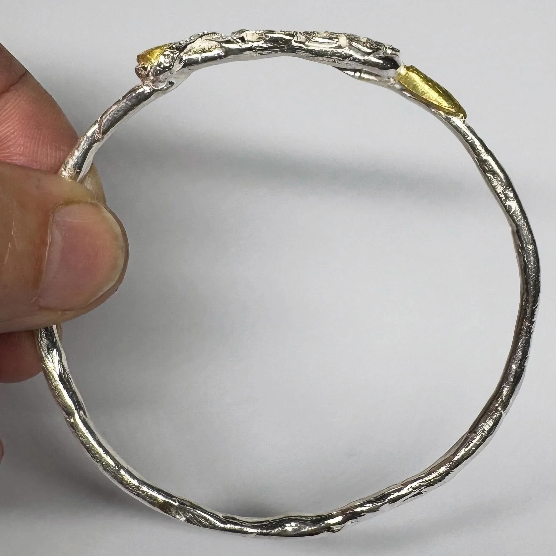 A bangle for Anita-Lynne.

Sterling silver, champagne diamonds and yellow gold plate.

Anita-Lynne has been supporting my work for a number of years now. This was the most recent commission. 
As Anita-Lynne is overseas we communicated via email to ge