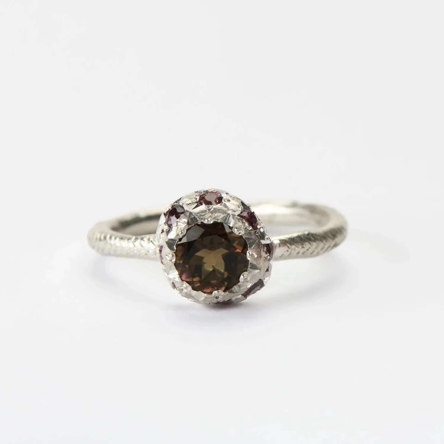 A beautiful combination of natural gemstones.

#117.
Series of One.
Hand engraved sterling silver, set with a central brown tourmaline and surrounded by natural coloured sapphires.

Available at the studio (open by appointment) and on the online stor