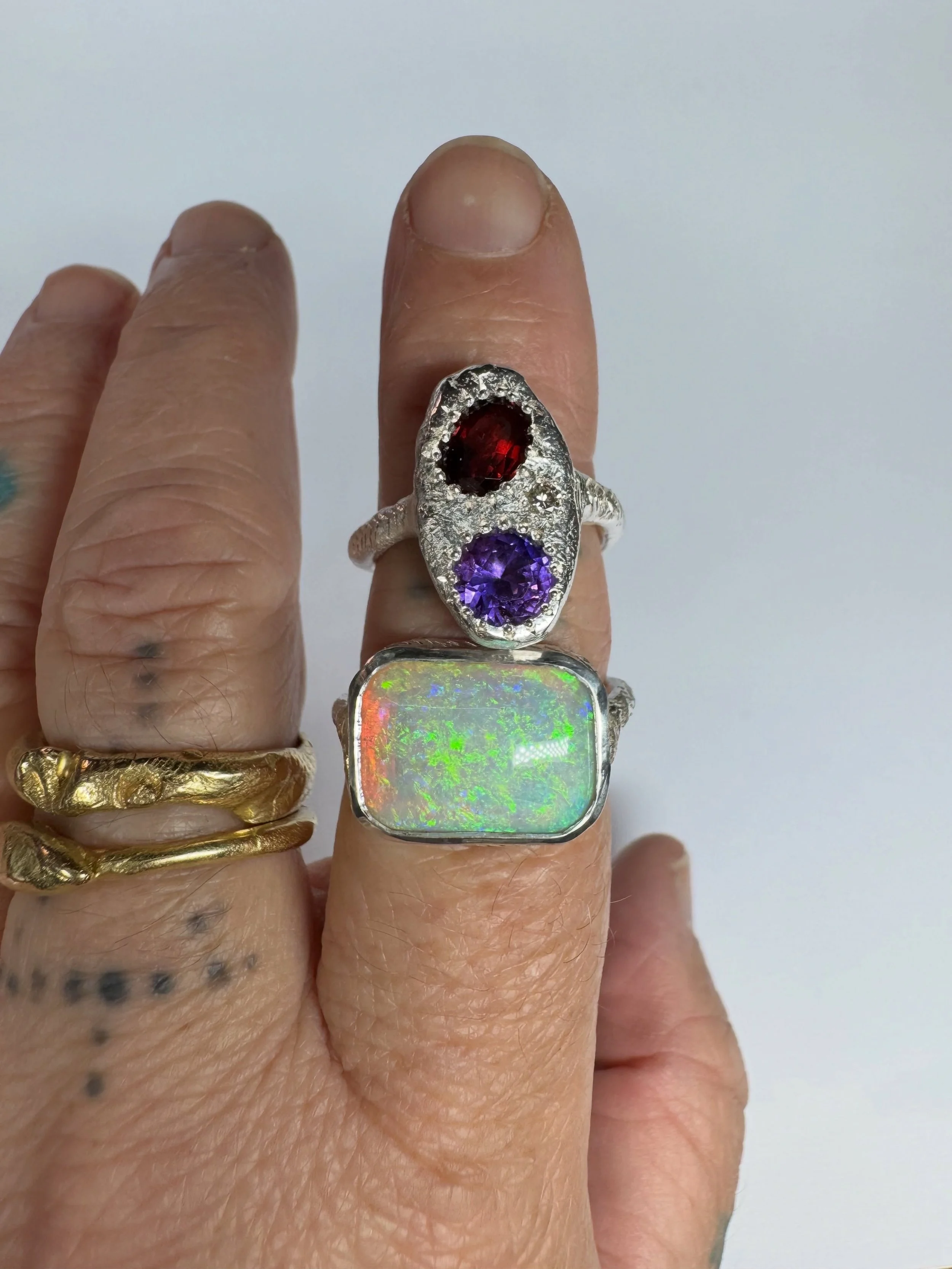 Rings for Gemma.

These two custom rings were handmade for Gemma using her own heirloom gemstones.

The first is a bespoke opal ring in sterling silver with hand engraving.

The second is a custom Journey Keepsake Protection Ring, made slightly large