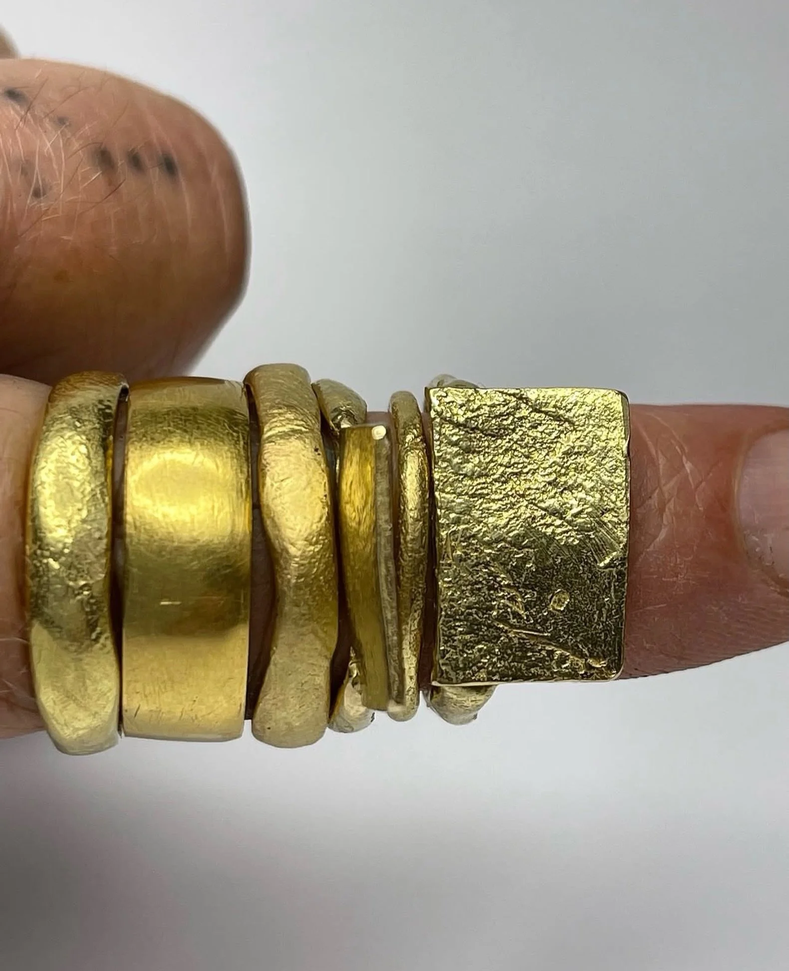 18ct yellow gold has a beautiful lustre to it, due to the higher percentage of gold in the alloy: 750/1000. 750 parts pure gold, 250 parts silver and copper to work harden the metal. So it is a rich bright yellow colour. 

From the left: 

Wonky Wedd