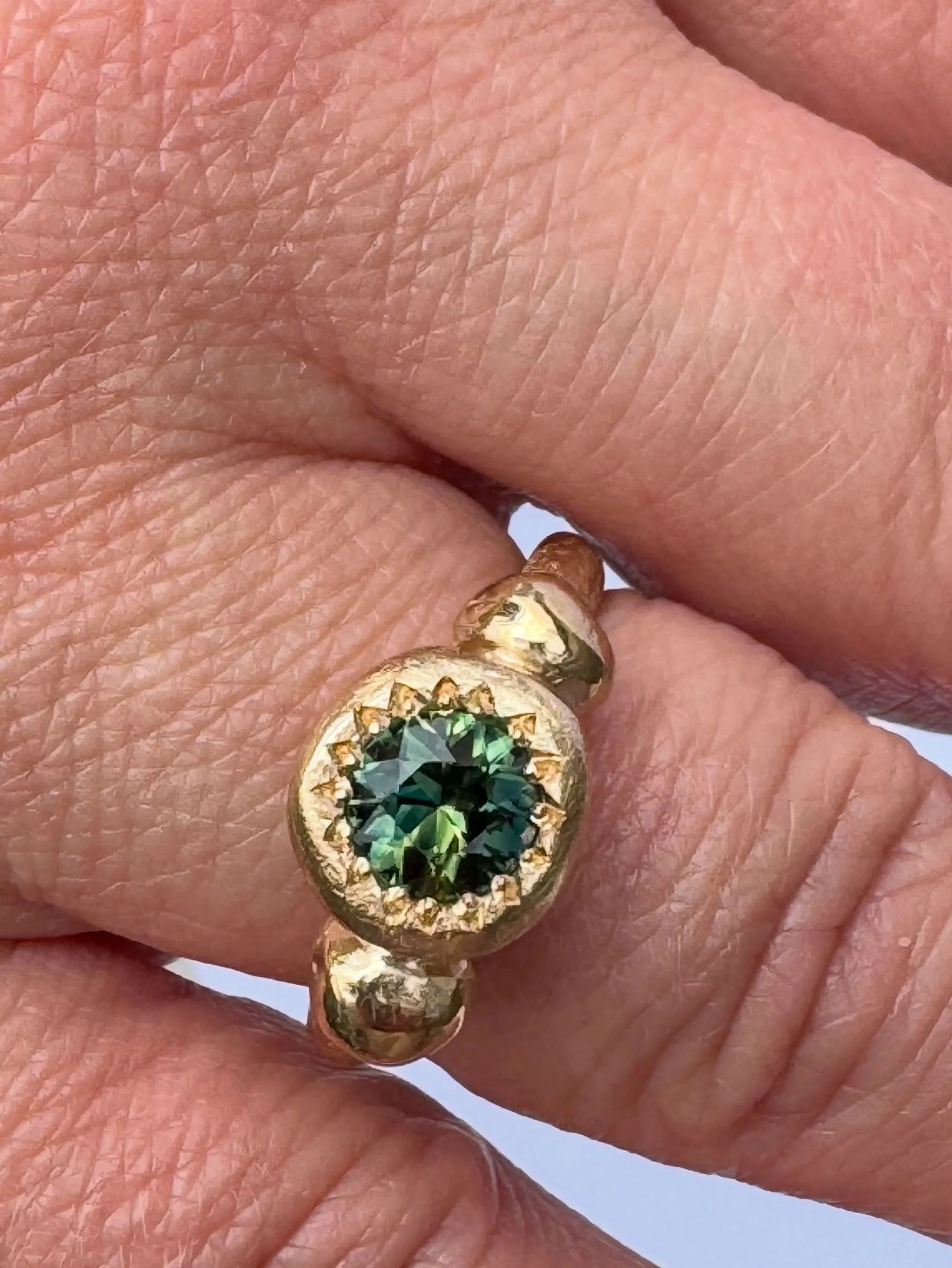 I named this ring Metier because the ring is strong and sure. Metier meaning an area of activity in which a person excels.

The setting here is heavy! The large granules supporting the central sapphire, everything is well suited here, and each elemen